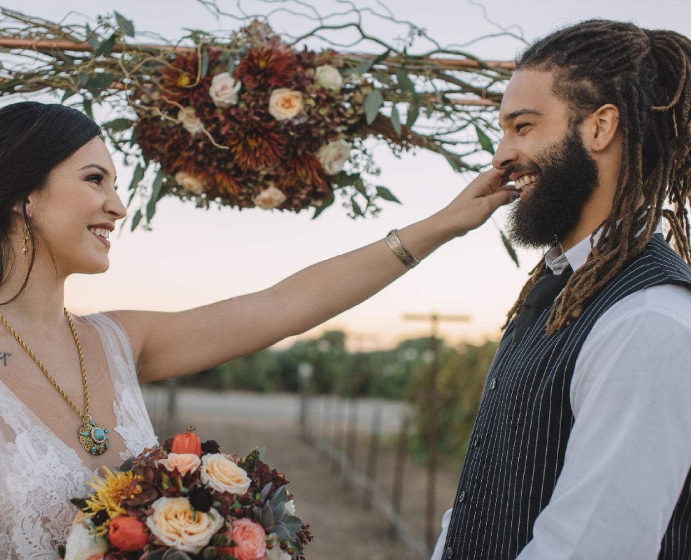 Bride wearing turquoise statement necklace for vineyard wedding